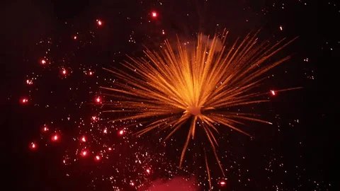 Golden fireworks bursting in the night sky