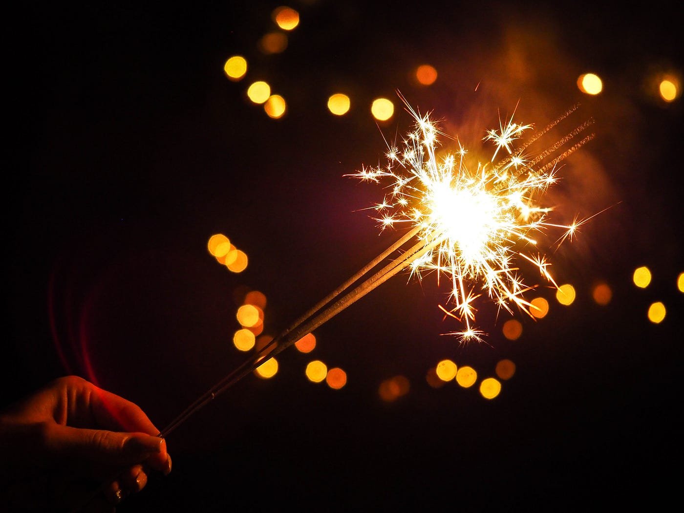 Hand holding a lit sparkler